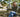 Woman on a park bench using a simple flip phone after switching to a dumb phone, smartphone set aside
