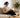 Woman reading a book on a sofa with her phone set aside in afternoon sunlight