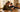 Mother and young son reviewing a simple flip phone at the kitchen table — choosing a first phone for kids