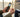 Hands inserting a SIM card into an unlocked phone at an airport gate