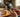 Open flip phone resting on a cozy wooden table with hands mid-text in warm home lighting