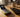 Flip phone showing full battery icon resting on a wooden desk next to a smartphonre with low battery icon.