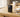 Compact MP3 player without WiFi sitting on a wooden desk beside wireless earbuds in soft morning light